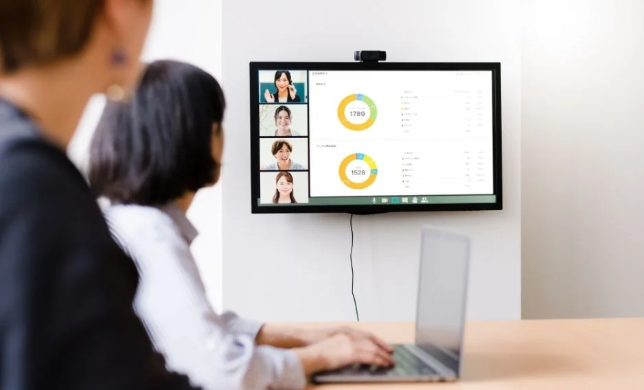 2名の社員がモニターに移された円グラフを見ながらWeb会議をしている写真